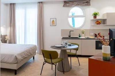 a bedroom with a bed and a table and a kitchen at Pupa Ru Capu in Palermo