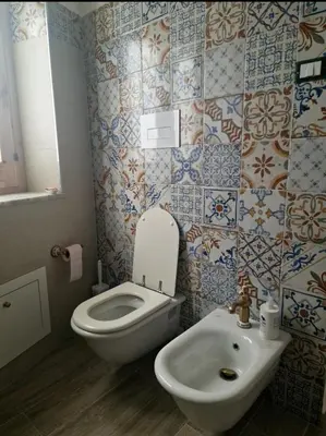 a bathroom with a white toilet and a sink at Marea in Palermo