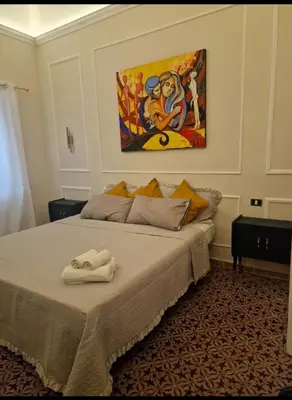 a bedroom with a bed with a painting on the wall at Marea in Palermo