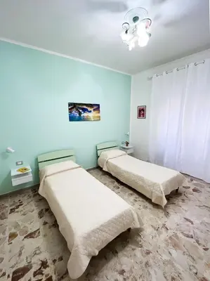 two beds in a room with blue walls at Brezza Di Mare Palermo in Palermo