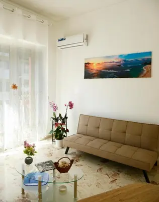 a living room with a couch and a glass table at Brezza Di Mare Palermo in Palermo