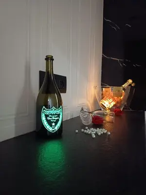 a green bottle of wine sitting on a table with a candle at La Stanza del Viaggiatore in Palermo