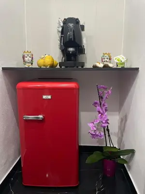 a red refrigerator in a room with a shelf at La Stanza del Viaggiatore in Palermo