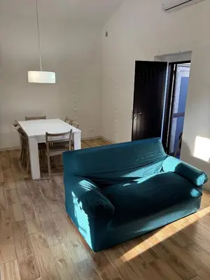 a green couch in a living room with a table at Valley Casale in Belmonte Mezzagno