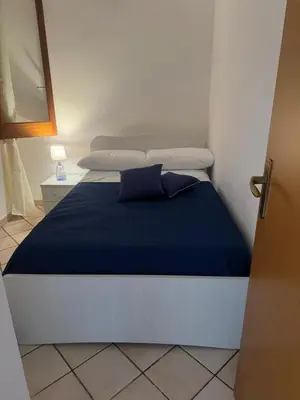 a bedroom with a bed with blue sheets and pillows at Lulu' Home - Guidaloca - Scopello in Scopello