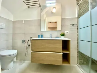 a bathroom with a sink and a toilet and a mirror at Loft Pergola, posizione strategica in Castellammare del Golfo