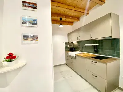 a kitchen with white cabinets and green tiles at Loft Pergola, posizione strategica in Castellammare del Golfo