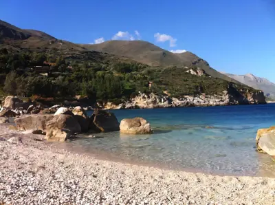 a rocky beach with mountains in the background at Villa Dream House Scopello in Scopello