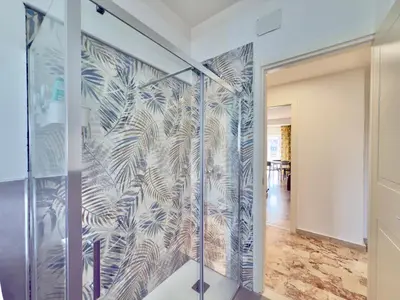 a hallway with a glass wall with a mural of palm trees at Cantieri 58 in Palermo