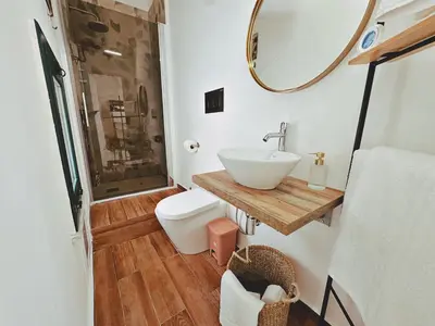 a bathroom with a sink and a toilet and a mirror at Oxalis Rooms & Suite in Palermo