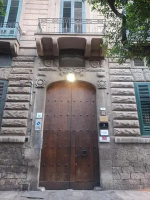 a large wooden door on a building with a balcony at Art suite palermo in Palermo
