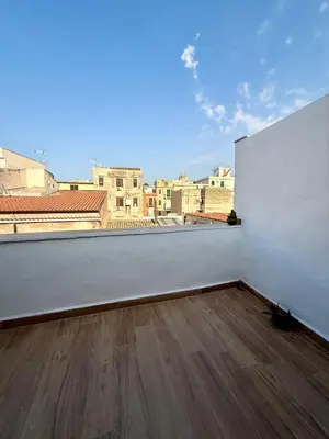 a room with a white wall and a wooden floor at 30House in Palermo