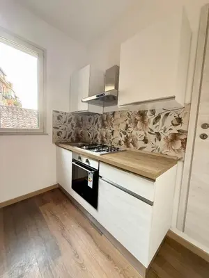 a kitchen with white cabinets and a stove top oven at 30House in Palermo