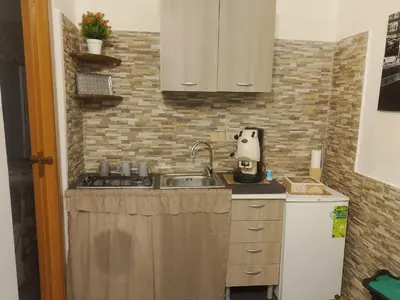 a small kitchen with a sink and a refrigerator at La casetta di Barbara in Palermo