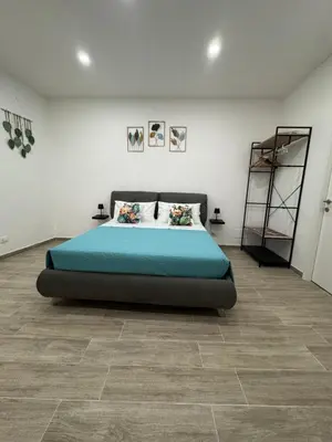 a bedroom with a large bed in a white room at Cristofarohome2 in Palermo