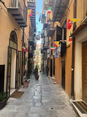 an alley in an old town with flags on buildings at Cristofarohome2 in Palermo