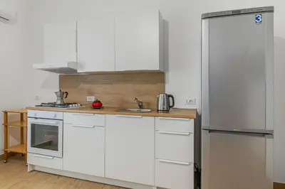 a kitchen with white cabinets and a refrigerator at GuestHost - Seaview Apartments near Palermo in Palermo