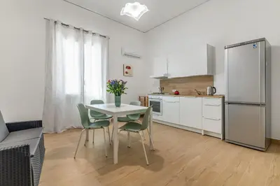 a kitchen with a table and chairs and a refrigerator at GuestHost - Seaview Apartments near Palermo in Palermo
