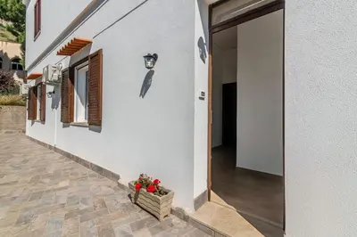 a door to a house with a basket of flowers at GuestHost - Seaview Apartments near Palermo in Palermo