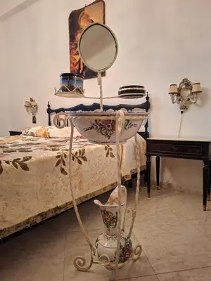 a mirror on a stand next to a bed at Casa Mirella in Aspra