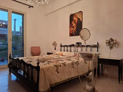 a bedroom with a bed with a mirror and a table at Casa Mirella in Aspra