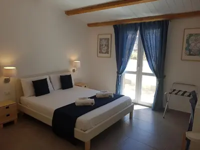 a bedroom with a bed and a large window at B&B Cala Peppa in Palermo
