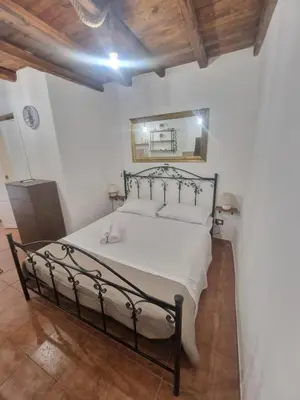 a bedroom with a large bed with white sheets at Al vicolo holiday home in Palermo