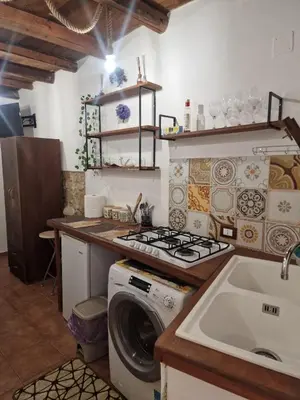 a kitchen with a washing machine and a sink at Al vicolo holiday home in Palermo