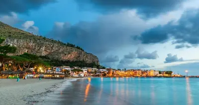 a view of a beach with a town in the background at La Casetta di Lilla in Palermo