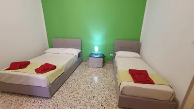 two beds in a room with green walls at Casa Nonna Rosa in Balestrate