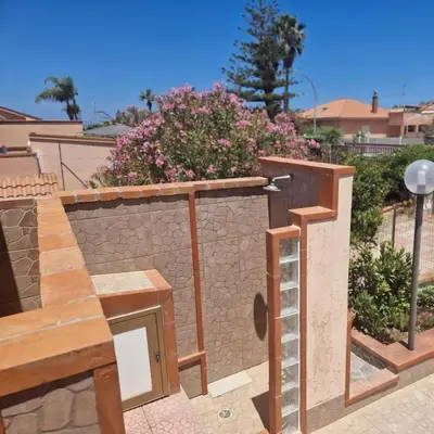 a retaining wall with a ladder next to a house at Silville in Campofelice di Roccella