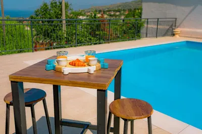 a table with a tray of food next to a pool at villa ulivo rovetto in Mandra Capreria