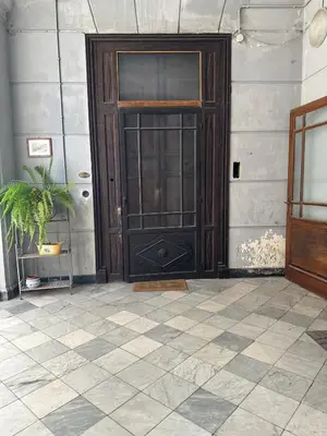 a wooden door in a room with a tile floor at La finestra sugli archi in Palermo