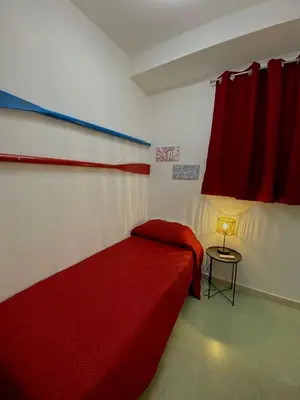 a bedroom with a red bed and a red curtain at Casimiro in Porticello