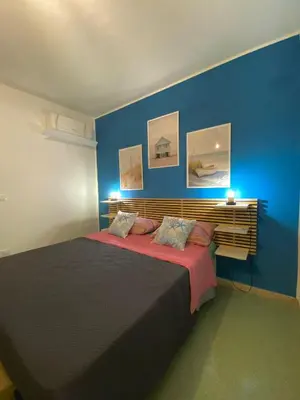a bedroom with a large bed with blue walls at Casimiro in Porticello