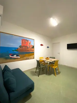 a living room with a blue couch and a table at Casimiro in Porticello