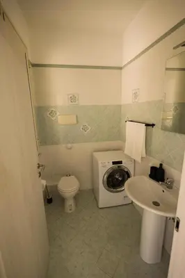 a bathroom with a washing machine and a sink at appartamento san felice in Bagheria