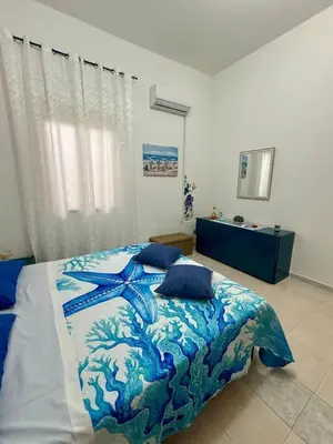 a bedroom with a blue and white bed with pillows at Piccolo Brasile Home in Capaci