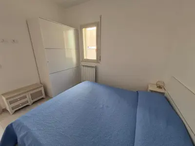 a bedroom with a blue bed and a window at ammare da mari in Castellammare del Golfo