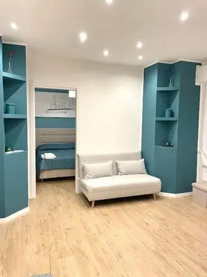 a living room with a white couch and blue shelves at Toselli 32 in Palermo