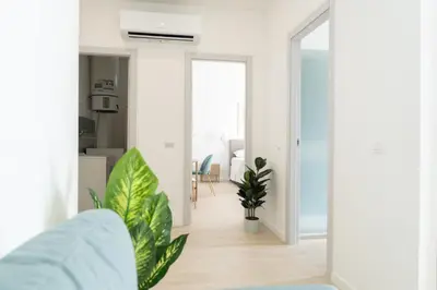 a living room with white walls and a blue couch at Light Charme, Sun Light Apartment a due passi dalla PIAZZA DUOMO in Terrasini
