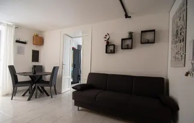 a living room with a black couch and a table at A Calat'i Jurici in Palermo