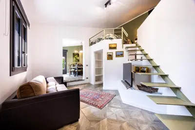 a living room with a staircase and a couch at Ibis Lodge With Swimming Pool in Palermo