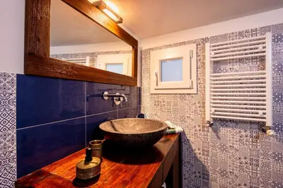 a bathroom with a bowl sink on a wooden counter at Ibis Lodge With Swimming Pool in Palermo