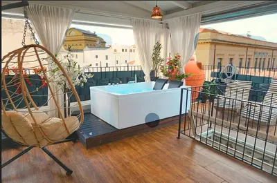 a room with a tub and a chair on a balcony at Teatro Massimo Terrace relax suite in Palermo