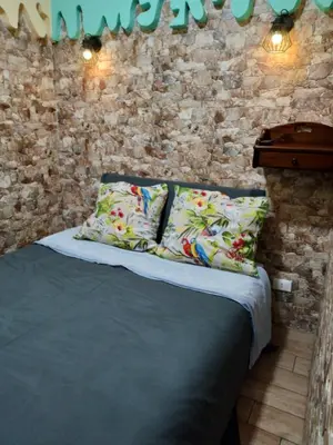 a bed with two pillows and a brick wall at Casa Porta Nuova 1989 in Palermo