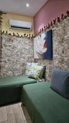a room with two green beds and a wall at Casa Porta Nuova 1989 in Palermo