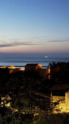 a view of the ocean with a house and the horizon at Giardino Segreto - Affitta Camere in Castellammare del Golfo