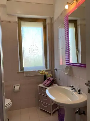 a bathroom with a sink and a toilet and a window at Appartamento Citreum in Balestrate