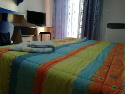 a bed with a colorful blanket on top of it at CASA ARENA - Affitti Brevi in Bagheria